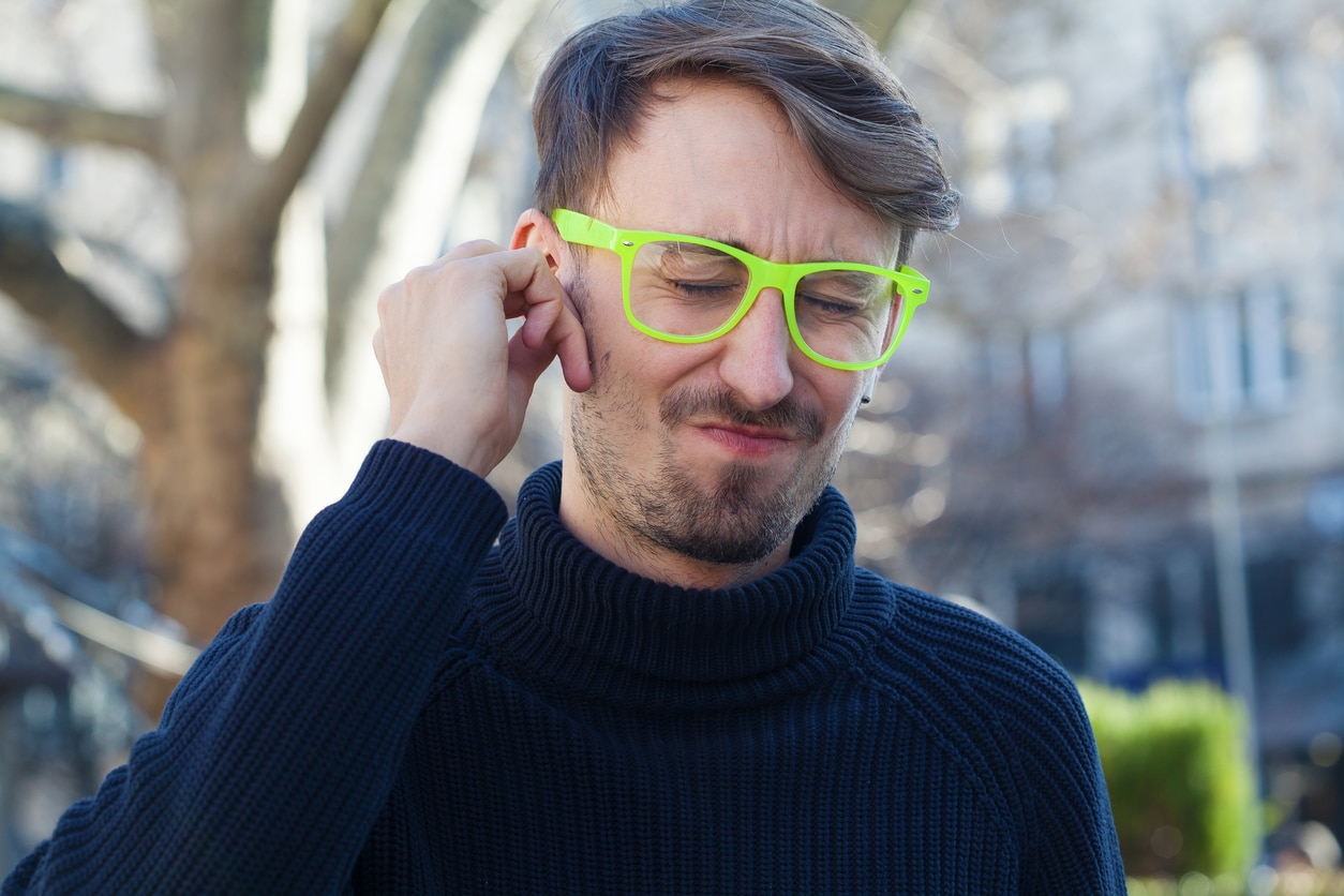 Man with ear pain holds ear