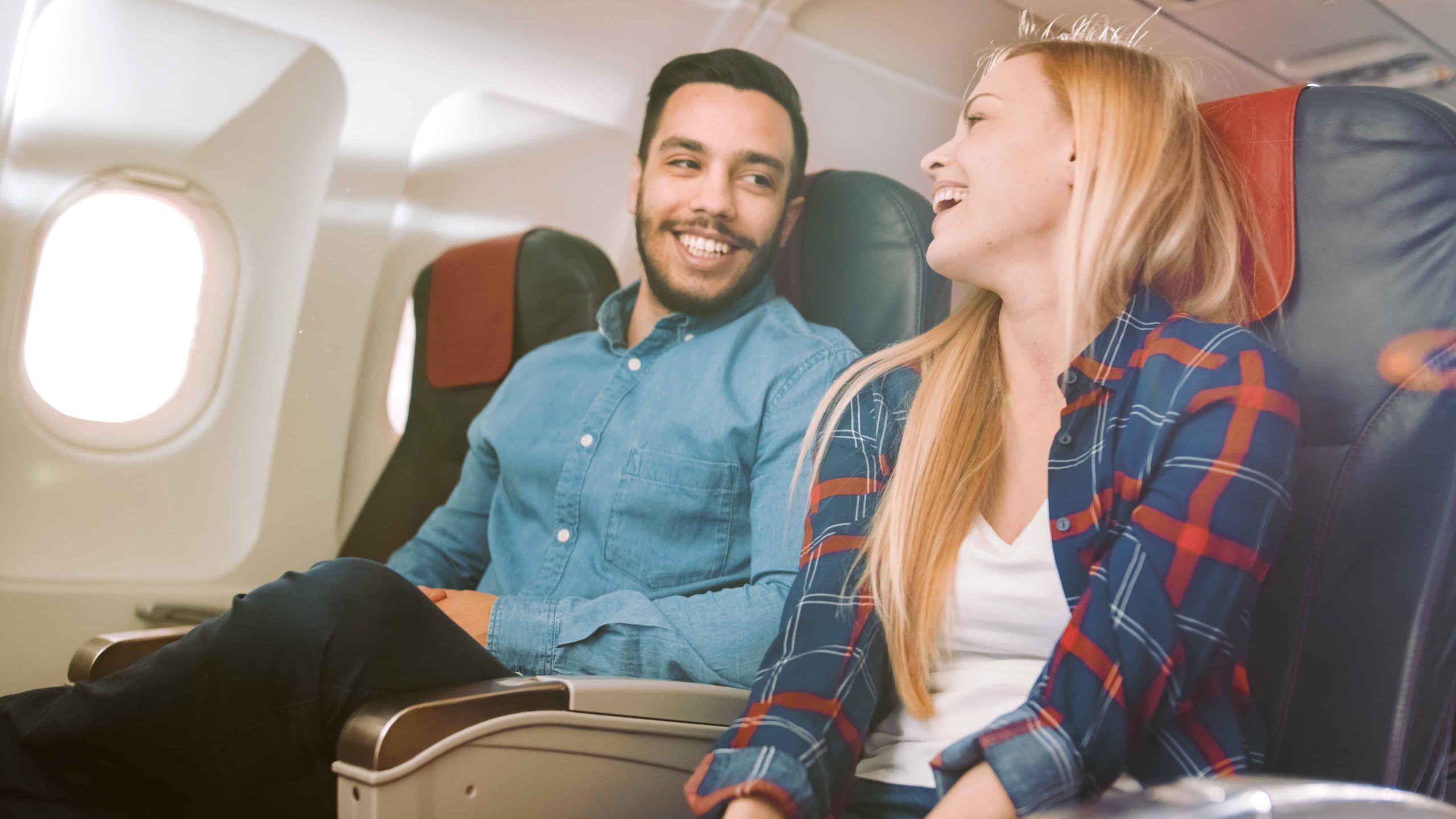 man and woman talking on airplane