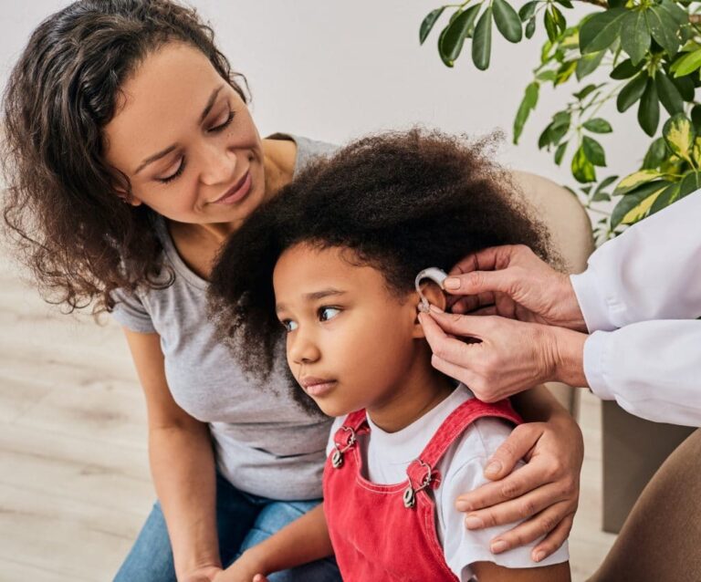 Little girl with her mother getting fitted for hearing aids.