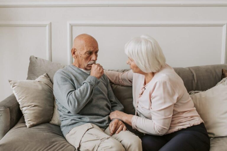 man coughing next to woman