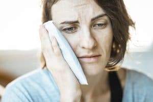 Woman with a cold pack on her face to relieve ear pressure.